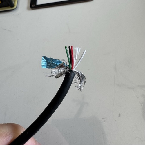 USB cable stripped with red and black wires kept